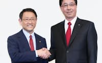 記者会見で握手するトヨタ自動車の豊田社長(左)とマツダの小飼社長（5月13日午後、東京都港区）