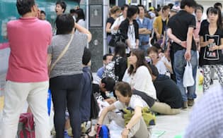 地震の影響で新幹線のダイヤが乱れ、ホームに座り込む人たち（30日夜、JR東京駅）