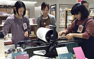 活版の印刷機を操る女性デザイナーたち（東京・新宿の伊勢丹新宿本店）
