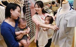 授乳服を買いに来た客(左)を接客するモーハウスの子連れ勤務の従業員（東京都渋谷区）