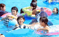 強い日差しの下、プールで泳ぐ子供たち（5日午前、東京都練馬区のとしまえん）