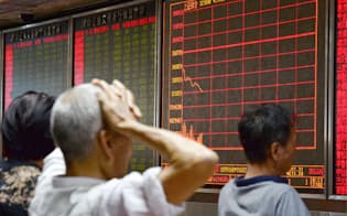上海株式市場が急落し、北京の証券会社で頭を抱える個人投資家（24日）=共同