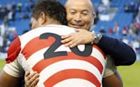 南アフリカに勝利し、マフィ(手前)と抱き合うジョーンズ・ヘッドコーチ(19日、ブライトン)=共同