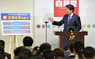 記者会見で新たな「3本の矢」を目標として掲げる安倍首相（24日夕、東京・永田町の党本部）=共同