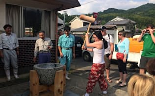 明日香村の民泊で餅つきを体験する外国人観光客=飛鳥ニューツーリズム協議会提供