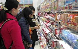 外国語のできる店員が中国人観光客に商品の説明をする（東京都千代田区）