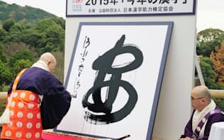2015年の世相を1字で表す漢字が決まり、「安」の字を揮毫する京都・清水寺の森清範貫主（15日）=共同