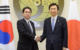 会談を前に韓国の尹炳世外相（右）と握手する岸田外相（28日、ソウルの韓国外務省）=共同