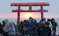 東日本大震災の津波で大きな被害を受けた宮城県東松島市の野蒜海岸から望む初日の出。雪が舞う中、大勢の人たちが集まり被災から5度目の新年を迎えた（1日朝）=共同