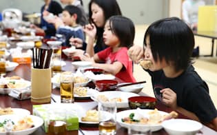 「ダイコンこども食堂」で、食卓を囲む子供たち（東京都練馬区）
