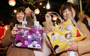 「おそ松さん」のイベントで、姉(右)が手作りした推し松バッグを手にする双子の姉妹（東京都豊島区のナムコ・ナンジャタウン）