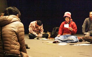 床に座った参加者の前で上田さんが詩を読む