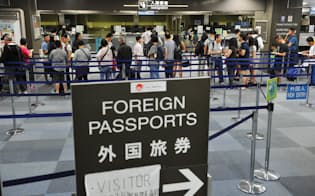 成田空港の入国審査ゲートに並ぶ外国人旅客（昨年7月）