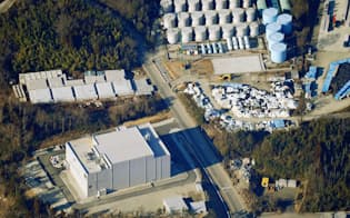 東京電力福島第1原発の敷地北側にある新しい焼却炉（左下）。右上は汚染水タンク（2月）=共同