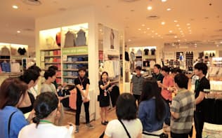 シンガポール国内の店舗で販売担当者らの話しを聞く学生。運営上の工夫などを質問した