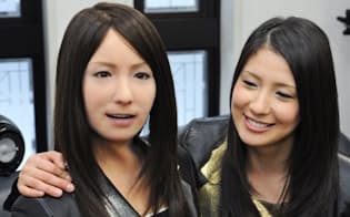 豊かな表情を再現できるヒト型ロボット（右はモデルとなった女性）