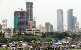 スラム街の奥でビルの建設ラッシュが続くムンバイ市街（2015年9月）=写真　浅原敬一郎