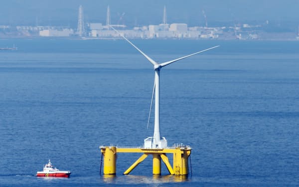 福島県沖約20キロに設置された浮体式洋上風力発電所の風車。後方は福島第1原発（2014年3月）