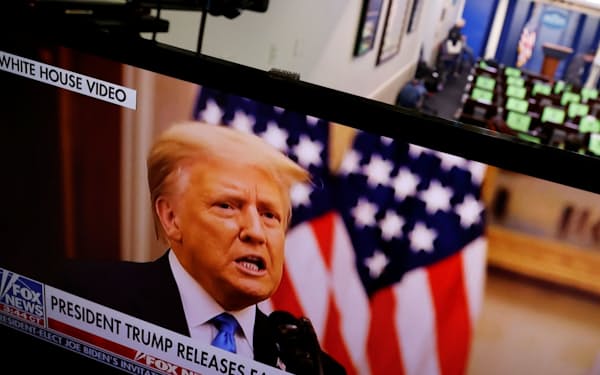 19日、トランプ米大統領のお別れ演説のビデオ動画を映すホワイトハウス記者会見室内のテレビ画面=ロイター