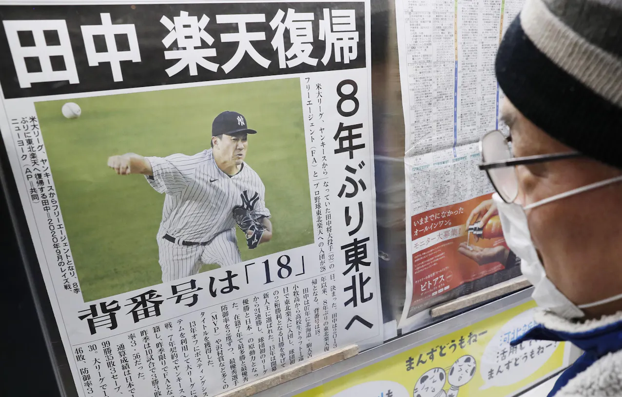 田中将大投手の楽天復帰を伝える地元紙号外を見る男性=28日午後、仙台市青葉区