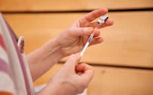 米ファイザーのワクチンを取り扱う医療関係者=ロイター 米ファイザーのワクチンを取り扱う医療関係者=ロイター