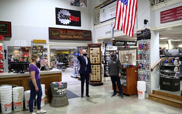 9日、ワシントンの商店を訪れ、中小企業対策をアピールするバイデン大統領（中央）=ロイター