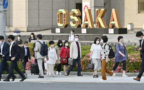 大阪市役所前を歩くマスク姿の人たち（14日午後）=共同