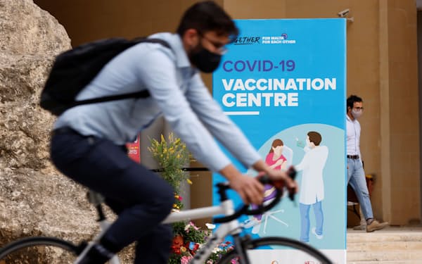 新型コロナウイルスを避ける移動手段として自転車は世界で人気だ（5月、マルタのワクチン接種施設の近く）=ロイター