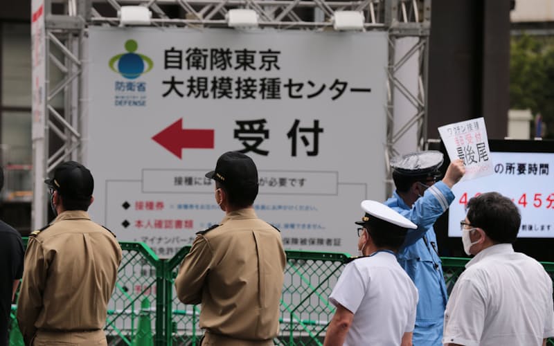 大規模接種センターでの自衛官や警察官らへの接種が始まり、「危機管理要員専用」の列に並ぶ人たち(14日、東京・大手町) 大規模接種センターでの自衛官や警察官らへの接種が始まり、「危機管理要員専用」の列に並ぶ人たち(14日、東京・大手町)