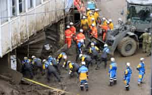 土石流の被災現場で捜索活動する警察官や消防隊員ら(6日、静岡県熱海市伊豆山)=共同 土石流の被災現場で捜索活動する警察官や消防隊員ら(6日、静岡県熱海市伊豆山)=共同