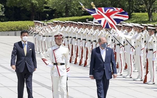 儀仗（ぎじょう）隊の栄誉礼を受けるウォレス英国防相（右）、左は岸防衛相＝20日午後、防衛省（代表撮影）