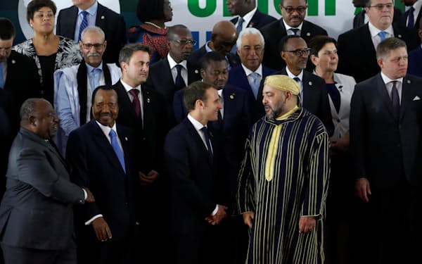 モロッコ国王のモハメド6世（左）と話すフランスのマクロン大統領（2017年11月、アビジャンでの国際会議）=ロイター