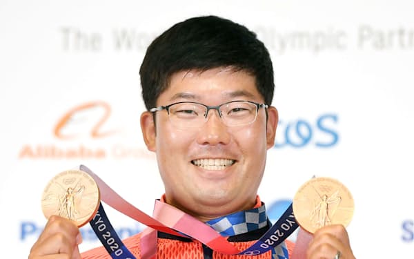 アーチェリー男子の個人と団体で獲得した2つの銅メダルを手に笑顔の古川高晴（1日、東京都内）＝代表撮影・共同