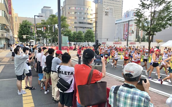 午前5時半の競技開始にもかかわらず、沿道には選手を一目見ようと観客が集まった（6日早朝、札幌市）
