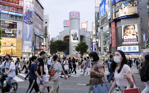 東京・渋谷のスクランブル交差点を歩く人たち。新型コロナウイルス対策分科会は今後2週間の人出を7月前半と比べ5割減らす必要があると提言した（12日午後）＝共同