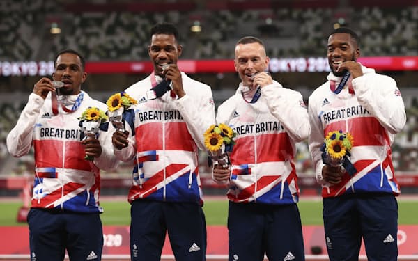 陸上男子400メートルリレーの銀メダルを手にポーズをとる英国のチジンドゥ・ウジャ（左端）ら（7日、国立競技場）＝ロイター