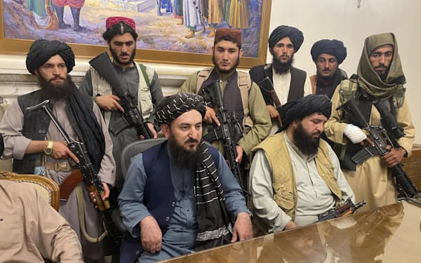 
15日、カブールのアフガニスタン大統領府を占拠した反政府武装勢力タリバンの戦闘員ら＝AP