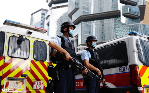 李宇軒被告が乗った車を警備する警察官(19日、香港)=ロイター