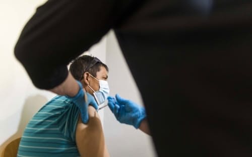 米フロリダ州レイクワースのワクチン接種会場で米ファイザー・独ビオンテック製の新型コロナウイルスワクチンを投与する医療従事者。2021年8月13日金曜日撮影。（PHOTOGRAPH BY SAUL MARTINEZ, BLOOMBERG VIA GETTY）