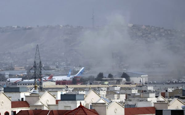 自爆テロ後に煙が上がるカブールの国際空港（８月２６日）AP