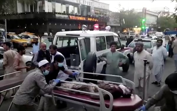 26日、カブールの国際空港付近での爆発後、病院に搬送される負傷者ら（1TV提供）＝ロイター