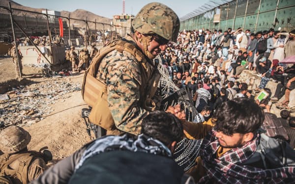 アフガニスタン・カブールの空港で、退避を希望するアフガン市民らに対応する米海兵隊員（26日）＝ロイター