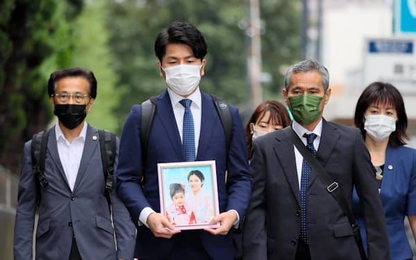 事故で亡くなった妻子の遺影を手に東京地裁に向かう松永拓也さん（左から２人目）