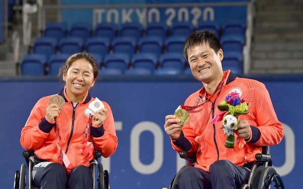 大会で獲得したメダルを手に、笑顔で記念撮影する上地結衣（左）と国枝慎吾＝共同