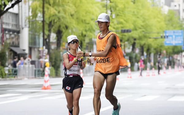 女子マラソン（視覚障害T12）の35キロ付近を伴走者と力走する金メダルの道下美里㊧＝共同