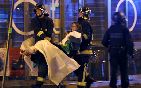 パリ同時テロの負傷者を運ぶ救急隊（15年、パリ・バタクラン劇場近く）＝ロイター