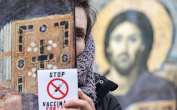 ルーマニアのブカレストで開かれたマスク着用義務化やワクチン接種に抗議する集会に参加する女性＝ロイター