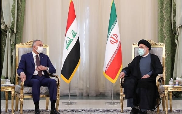 12日、テヘランで会談するイランのライシ大統領（右）とイラクのカディミ首相＝イラン大統領府提供・ロイター