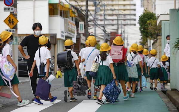 新学期が始まり、集団登校する児童ら（8月、大阪市）=共同