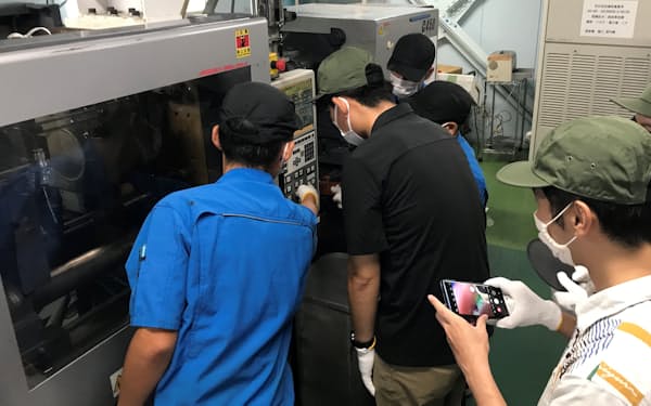 現場従業員が見学者に機械の操作方法などを説明する（9月、堺市の河辺商会が開いたプレイベント）